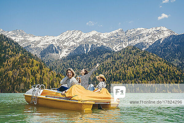 Friends on pedal boat with dog enjoying on Lake Ritsa