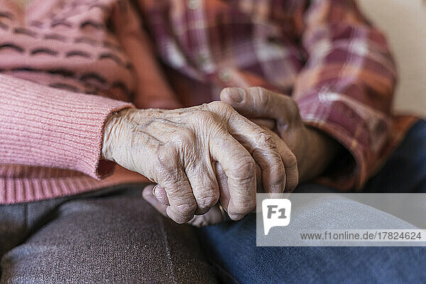 Mature man holding hands of senior woman at home