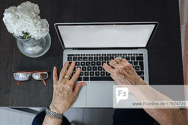 Hands of senior woman using laptop