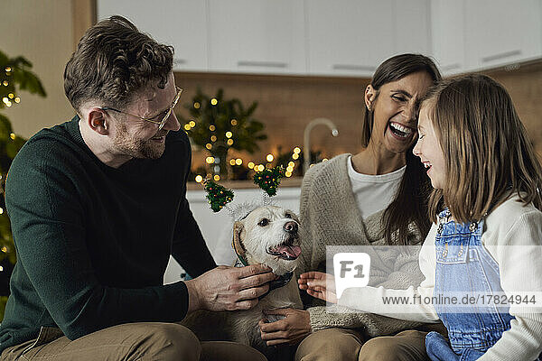 Happy family with dog enjoying Christmas time together at home