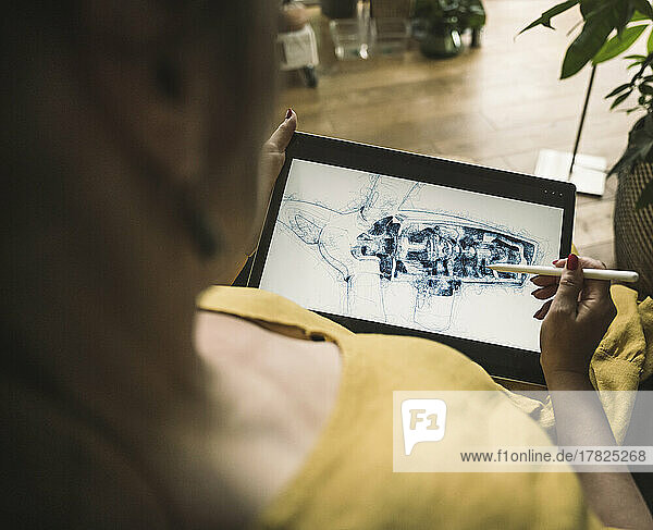Mature engineer sketching on graphic tablet at home office