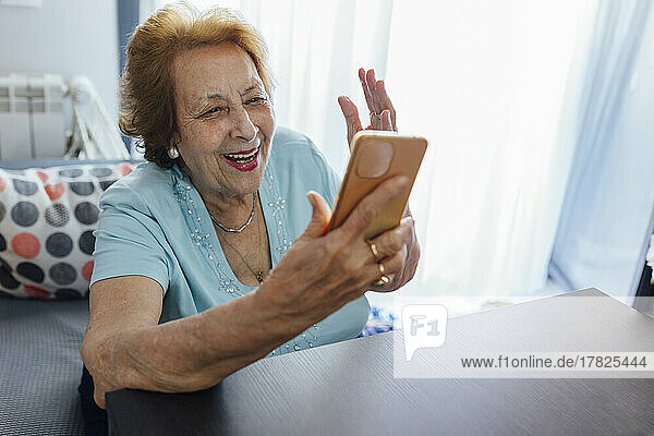 Glückliche ältere Frau  die zu Hause ihr Smartphone benutzt