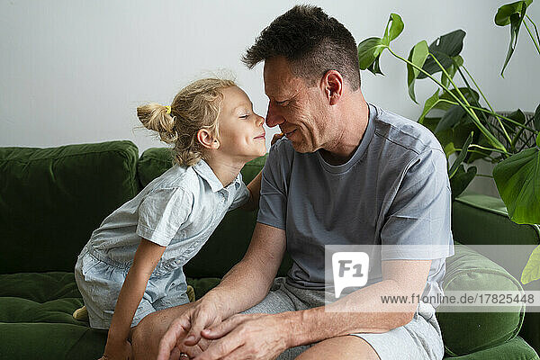 Father and daughter rubbing noses at home
