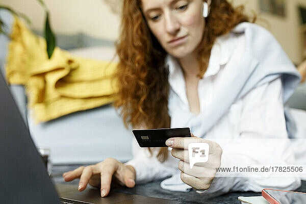 Woman using credit card for online shopping at home