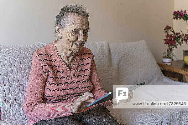Senior woman using tablet PC at home