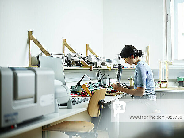 Techniker sitzt auf einem Stuhl und arbeitet im Elektroniklabor