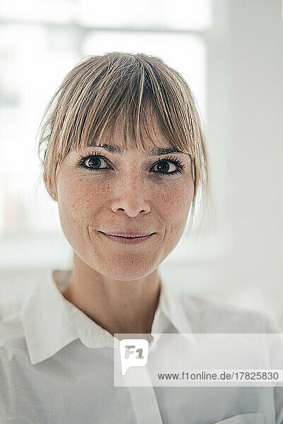Smiling businesswoman in white shirt at office