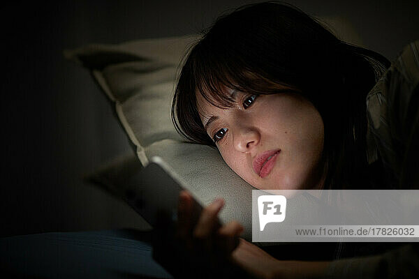 Japanese woman using smartphone in bed