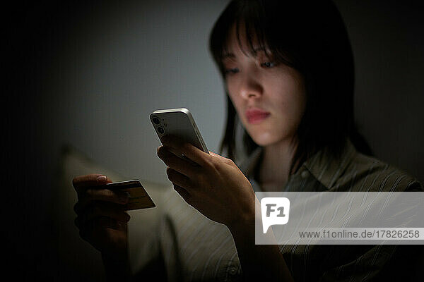 Japanese woman using smartphone in bed
