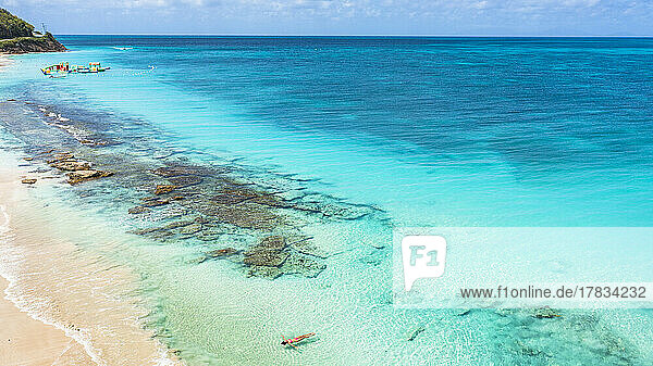 Woman floating in the crystal sea on idyllic tropical beach  overhead view  Antigua  Leeward Islands  West Indies  Caribbean  Central America