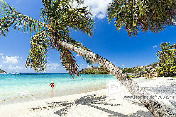 Fröhliche Frau beim Sonnenbaden im kristallklaren karibischen Meer  Antigua  Leeward Islands  Westindien  Karibik  Mittelamerika
