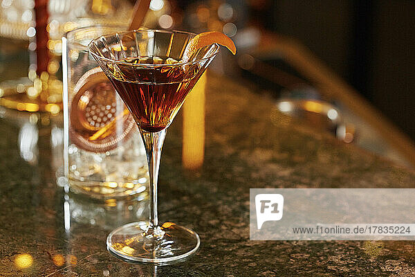 Whiskey-Cocktail im Martiniglas  garniert mit Orange