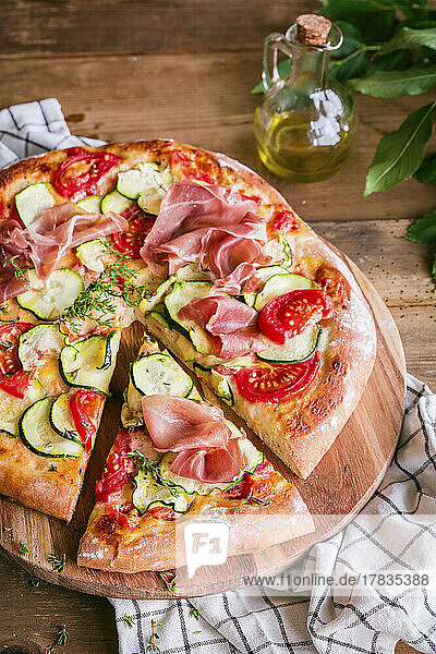 Hausgemachte Pizza mit Zucchini  Tomaten und Parmaschinken