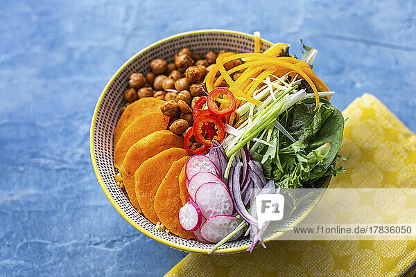 Veggie-Bowl mit Kichererbsen  Paprika  Salatblätter  Zwiebeln und Süßkartoffel