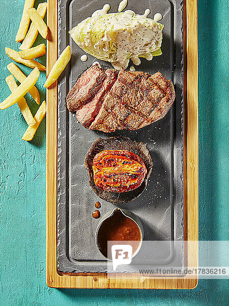 Steak platter with white cabbage  grilled tomato  sauce and chips