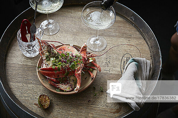Dressed lobster ready to serve with glasses of champagne being poured