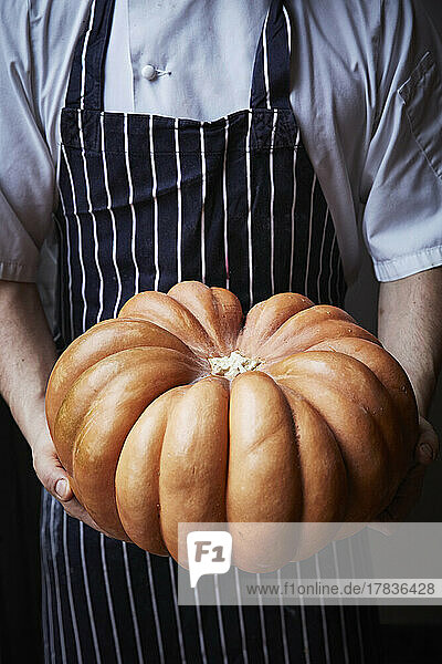 Large pumpkin held by a chef
