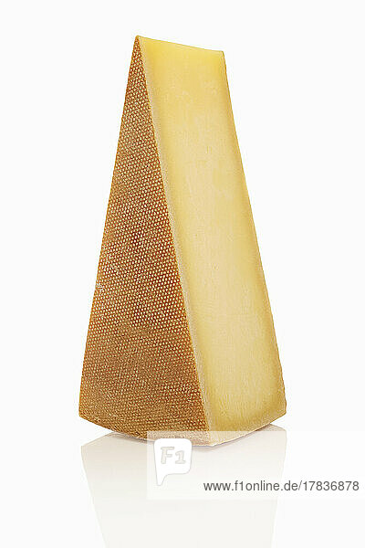 A piece of Gruyere against a white background
