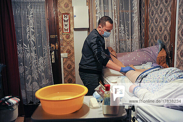 Private nurse performs a complete toilet in the home of an 86-year-old patient.