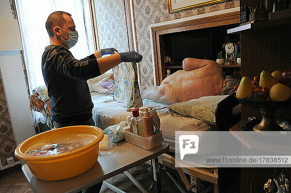Private nurse performs a complete toilet in the home of an 86-year-old patient.