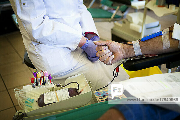 Donate blood at a blood collection facility.