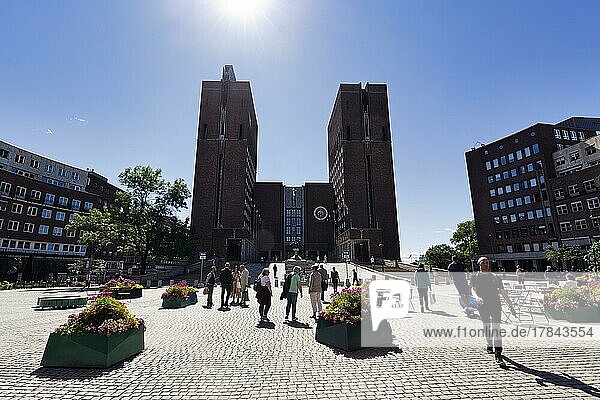 Fußgänger vor monumentalem Rathaus mit zwei Türmen  Nordseite im Sommer  Vergabeort Friedensnobelpreis  Gegenlicht  Wahrzeichen im Stadtzentrum  Oslo  Norwegen  Europa