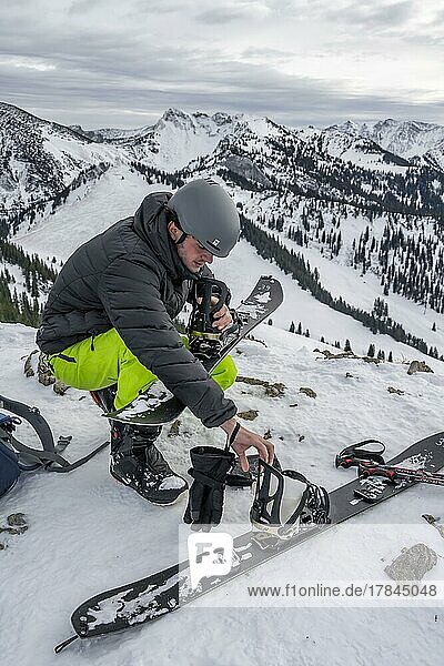 Skitourengeher  Mann baut sein Splitboard zusammen  Winter  Bayern  Deutschland  Europa