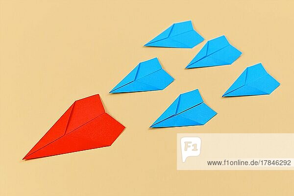Rotes Papierflugzeug führt blaue Flugzeuge an. Konzept für Entdeckung und Führung