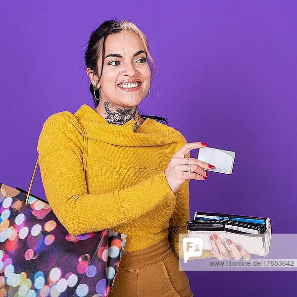 Eine Frau hält ihre Brieftasche und Einkaufstasche und zeigt eine Kreditkarte