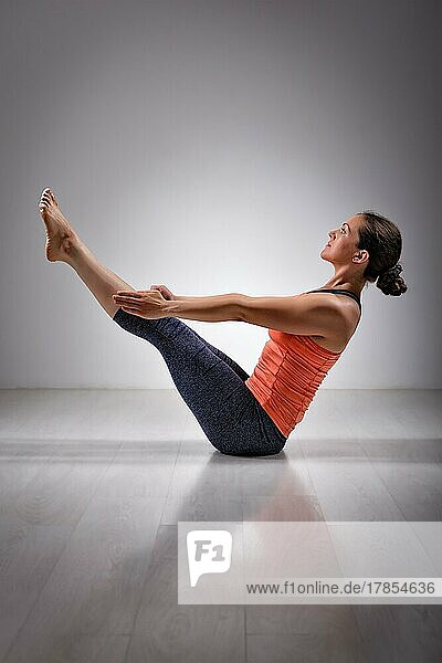 Schöne sportlich fit Yogini Frau Praktiken Yoga asana Paripurna navasana  Boot Pose