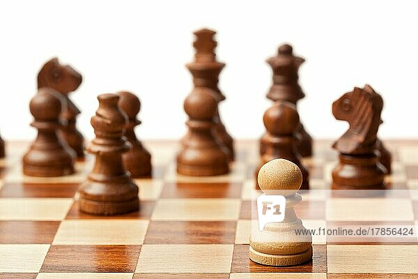 Ein Bauer gegen alle  hölzerne Schachfiguren auf einem Schachbrett. Selektiver Fokus  geringe Tiefenschärfe