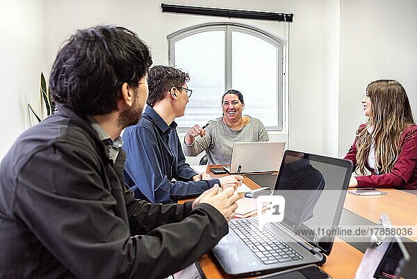 Menschen  die während einer Besprechung im Büro an Laptops arbeiten