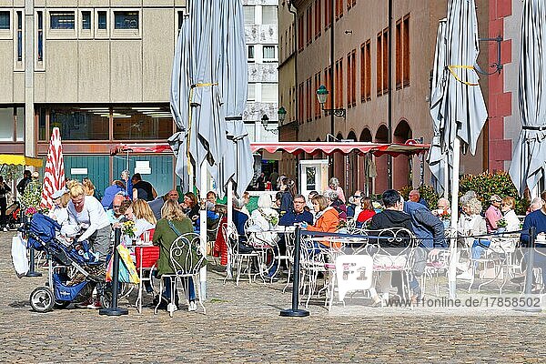 Menschen entspannen sich an einem sonnigen Tag in einem Straßencafé  Freiburg  Deutschland  Europa