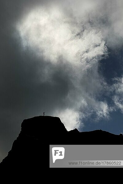 Dramatischer Himmel mit zwei Menschen vor Wolken auf einem Berg in Kirkjubæjarklaustur  Südisland  Island  Europa