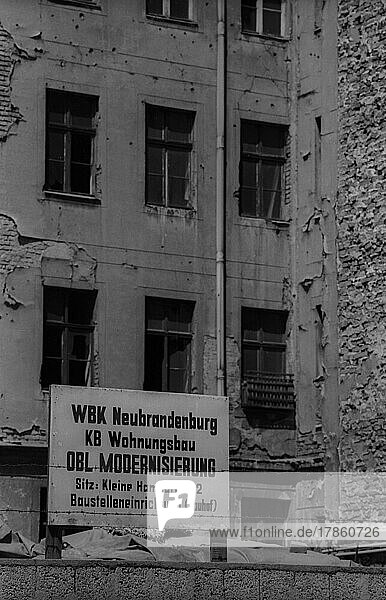 DDR  Berlin  17. 6. 1986  Firmenschild vor einer verfallener Fassade in der Auguststraße  WBK (Wohnungsbaukombinat) Neubrandenburg  KB Wohnungsbau  OBL Modernisierung