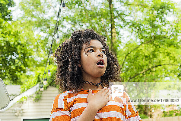 Child in backyard acting surprised