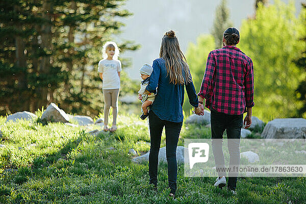 Family with baby and child playing in nature together and holdin