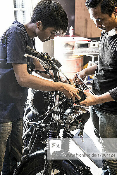 mechanic's working on motorcycle at custom bike shop in Bangkok