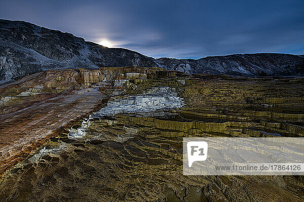 A full moon rises over Mammoth Hot Springs in Yellowstone Nation