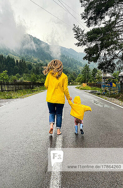 Mum and son in the yellow raincoat are running.