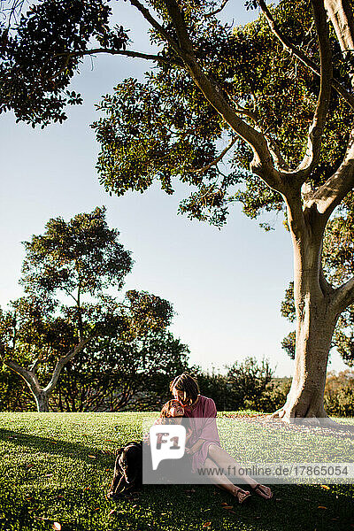 Mother & Daughter Posing Under Tree with Dog in San Diego