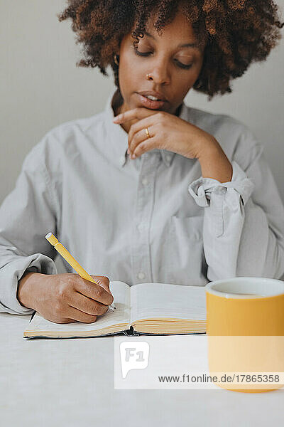 A thoughtful woman writes thoughts in a diary. Selective focus.