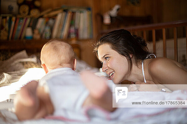 Mother lovingly looks at her baby in a cozy room