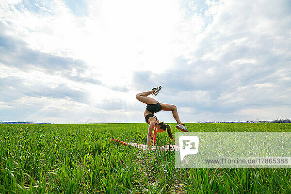 beautiful girl model on green grass do yoga