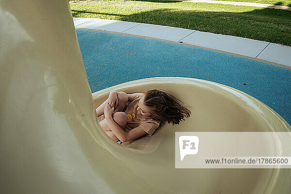 Young girl playing on slide at park