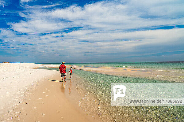 a father and son walking on the beach at gulf islands in Florida