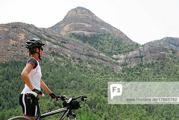 Cyclist woman admiring the mountainous landscape.