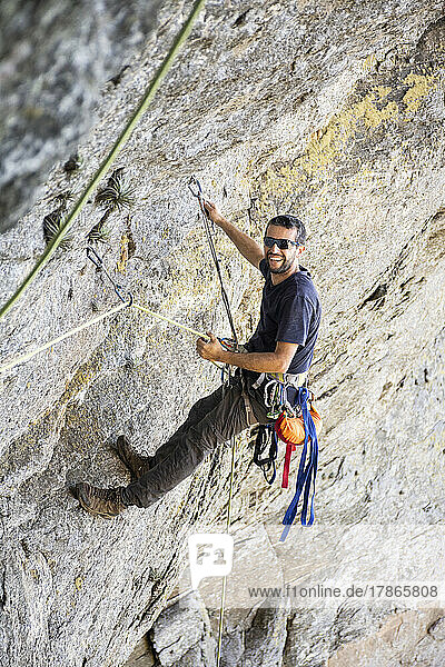 Beautiful view to rock climber climbing on steep rocky wall