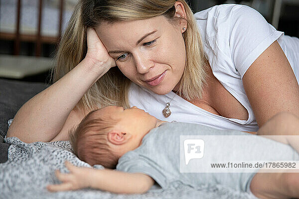 Young mother lovingly looks at her newborn