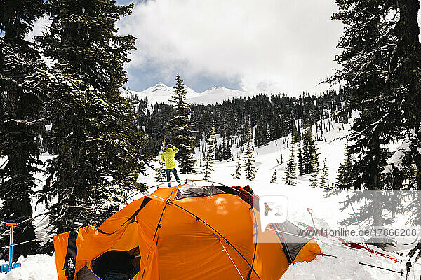A man stands near his tent in the Goat Rocks Wilderness